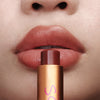 Augustinus Bader The Tinted Lip Balm - Shade 3 - model holding product next to lips
