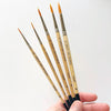 Close up of hand holding Emily Lex Studio Watercolor Paintbrush Set (5 pcs)