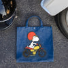 Three Potato Four 3P4 X Peanuts Vintage Market Tote - Snoopy Easy Rider - product shown on ground next to helmet and tire