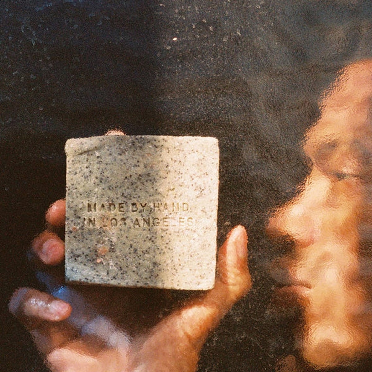Flamingo Estate Organics Exfoliating Peppermint Soap Brick (340 g) - product shown in water with person. 