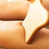 Tuuli Gua Sha Wooden Massage Paddle - model using product on leg