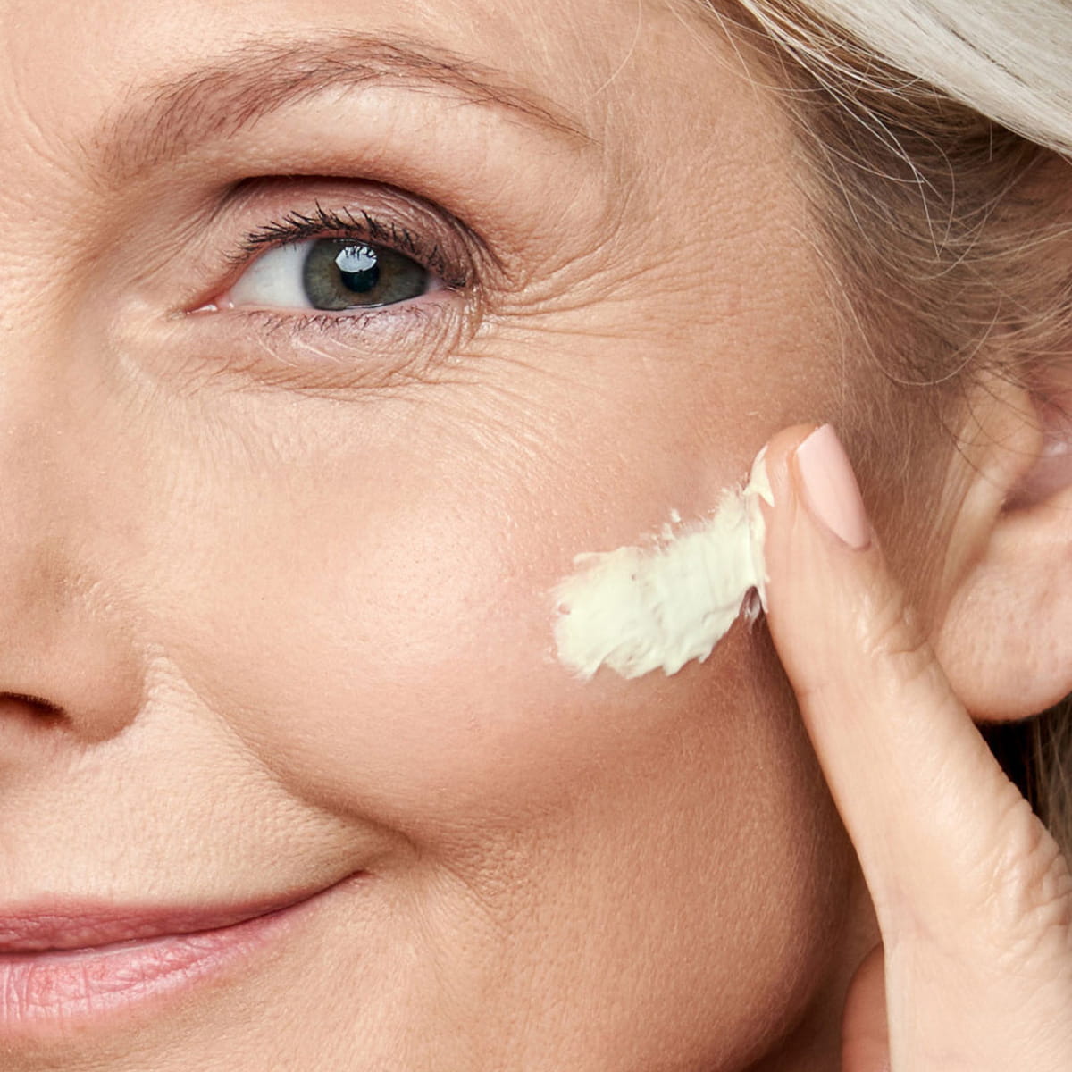 Close up of model applying Odacite Edelweiss Extreme Bioactive Renew Supreme Cream to face