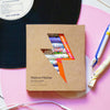 Maison Matine Discovery Set (11 x 2 ml), styled on a pink surface with a black vinyl record, earphones, in the background