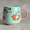 Idlewild Co Cats Ceramic Mug - product shown on countertop 