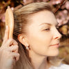 Snow Fox Skincare Gua Sha Hair & Scalp Brush: Premium Wooden Edition - model shown using product in hair