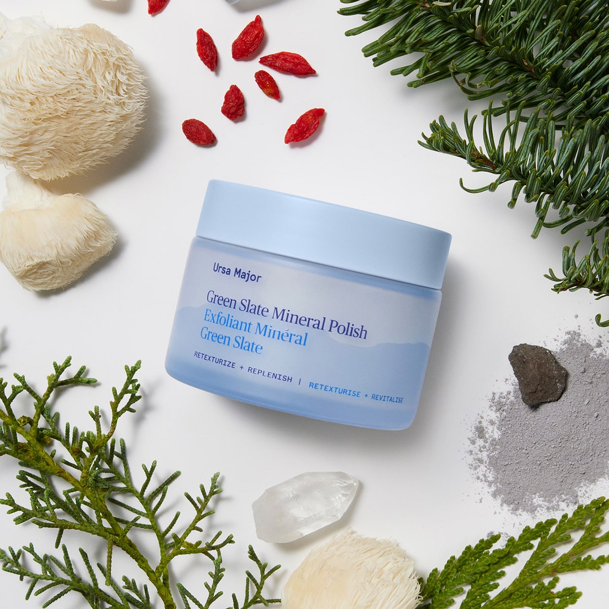 Ursa Major Green Slate Mineral Polish (3.88 oz) - product surrounded by plants, rocks and fruit. 