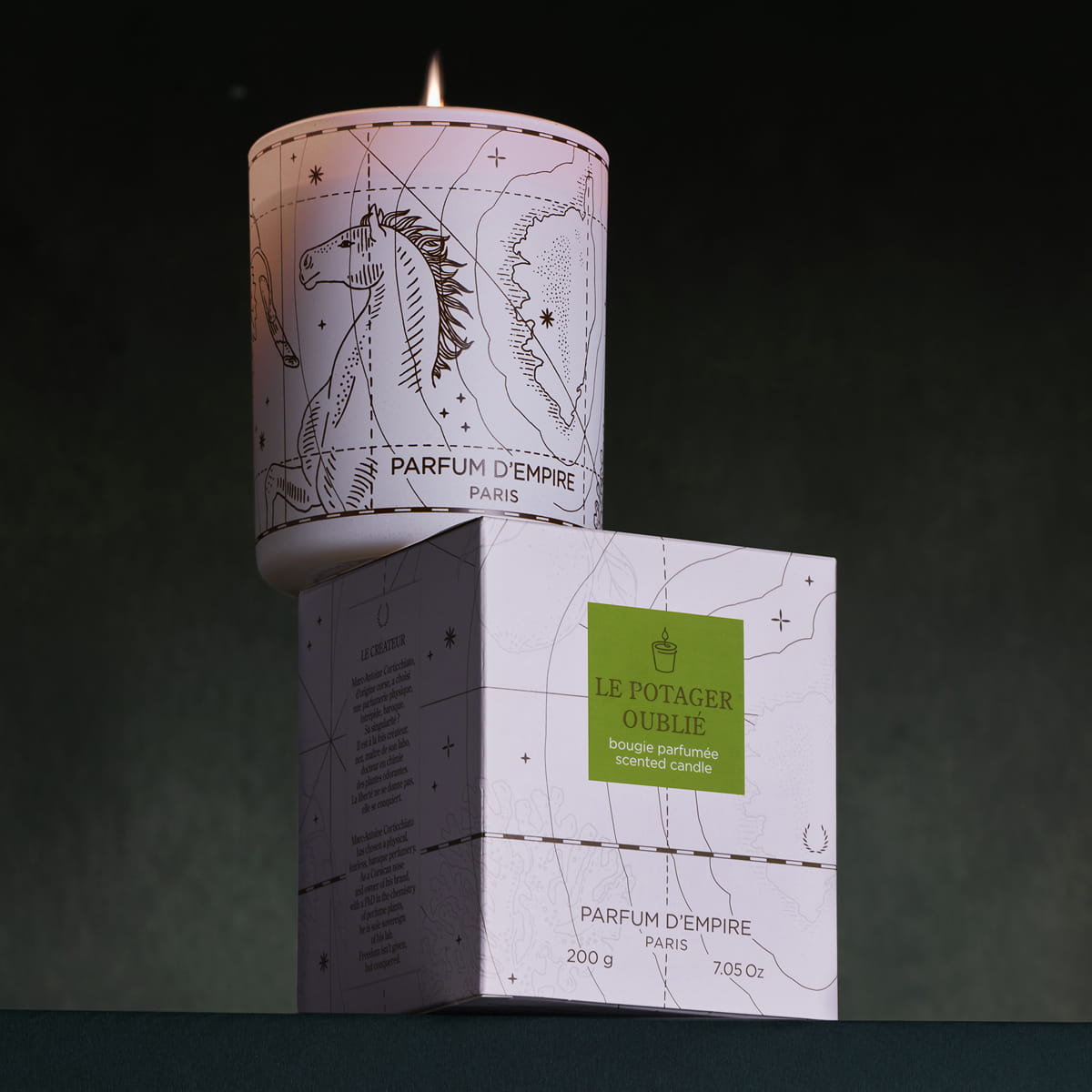 Parfum d'Empire Le Potager Oublie Scented Candle (200 g) shown lit sitting on box
