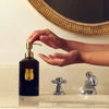 Lifestyle shot of model using Trudon Medie Hand Soap (350 ml) at bathroom sink