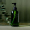 Koala Eco Apothecary Glass Bottle and Pump - product shown in front of glass and plant