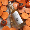 Flamingo Estate California Harvest Ambrosia Fuyu Honey Hachiya Persimmon Vinegar (408 ml) - product shown on top of persimmons.