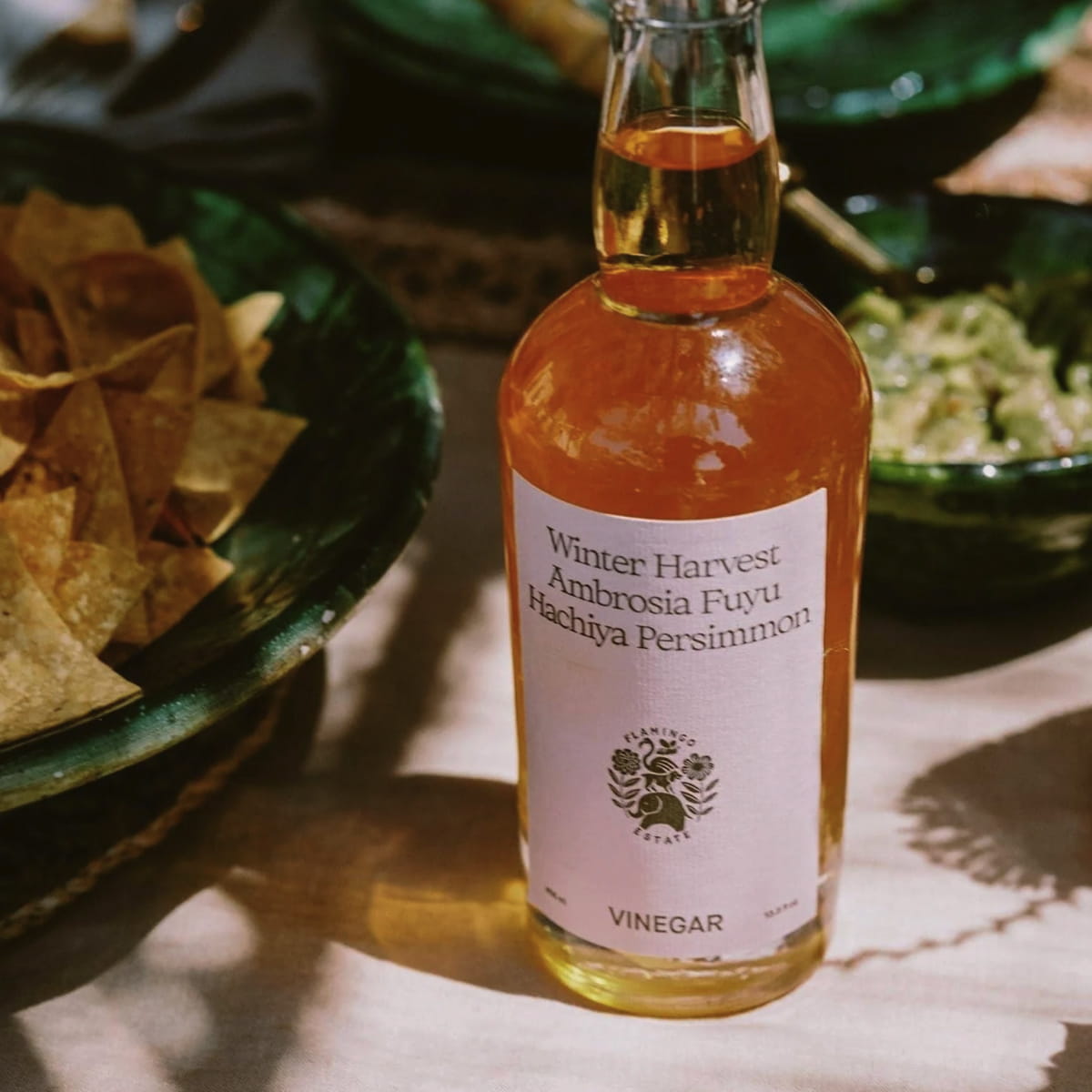 Flamingo Estate California Harvest Ambrosia Fuyu Honey Hachiya Persimmon Vinegar (408 ml) - product shown on table.