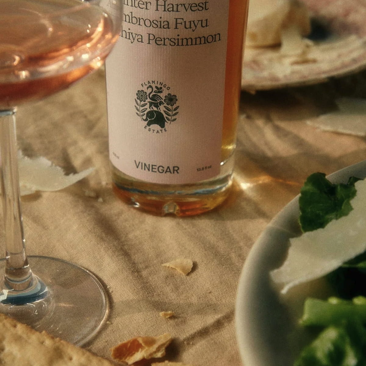 Flamingo Estate California Harvest Ambrosia Fuyu Honey Hachiya Persimmon Vinegar (408 ml) - product shown on table. 