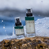 Lifestyle shot of Santos de Ibiza Facial Mist (100 ml and 50 ml) sitting on rock with ocean and waves crashing behind the rock