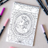 Antiquaria Cosmic Cowgirl Premium Coloring Book - product interior page shown next to pens