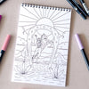 Antiquaria Cosmic Cowgirl Premium Coloring Book - product interior page shown next to pens