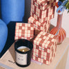 ROEN Candles Rue 52 Scented Candle - lit product shown next to product packaging