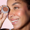 Odacite Color Balm SPF 50 - Bronze Jolie - model shown holding product