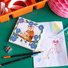 StoryTiles Small Tile - Under My Wings (1 pc) - product shown on green table with children's sketch. 