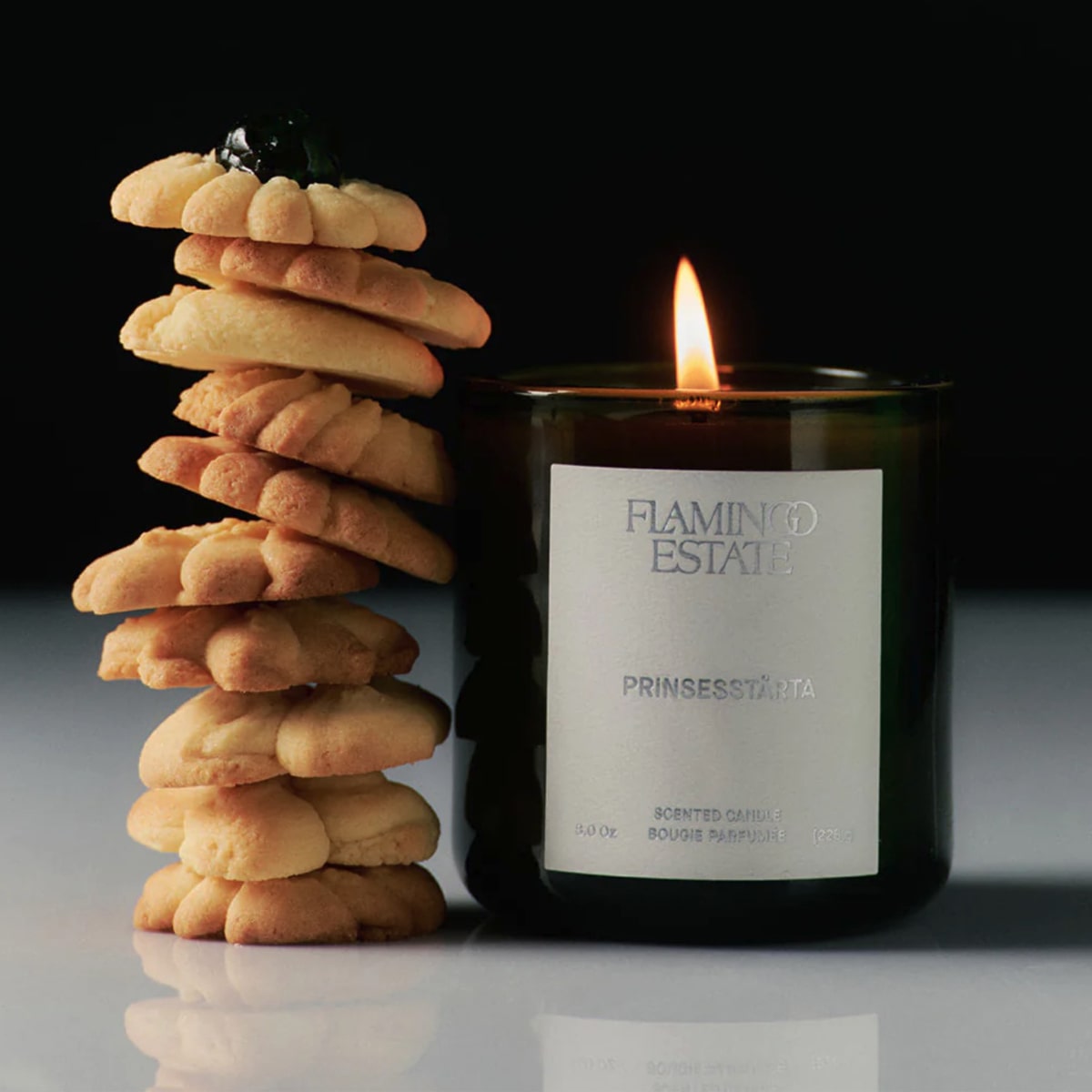 Flamingo Estate Organics Limited Edition Prinsesstarta Candle (226 g) - product shown lit next to cookies. 