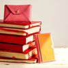 Immodest Cotton Scallop Wallet - Carnation + Orange - products shown on top of books