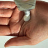 Artifact Hand & Nail Cream - Big Wave - model shown squeezing product into hand