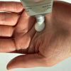 Artifact Hand & Nail Cream - Forecast - model shown squeezing product into palm