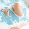 Bathorium Midnight Superbloom Crush Bath Soak - model shown inside bath with product