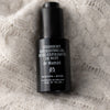 de Mamiel Overnight Exfoliating Oil - product shown on fabric