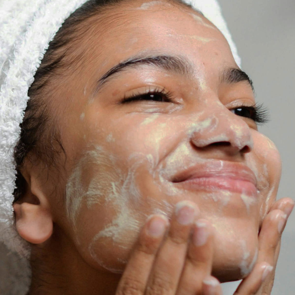 Model applying Odacite Edelweiss Extreme™ Hydra-Calm Cream Cleanser on face