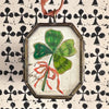 Maris Mirum Small Locket - Clover with Bow - product shown on decorative paper