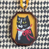 Maris Mirum Small Locket - Tuxedo Kitty - product shown on decorative paper