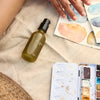 A.OK Botanical Body Oil - product shown next to watercolor painting and palette