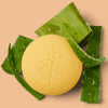 Kate McLeod Sun Stone After Sun Balm & Lotion Bar (3.5 oz) - product shown with aloe leaves on top.