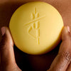 Kate McLeod Sun Stone After Sun Balm & Lotion Bar (3.5 oz) - product shown being held. 