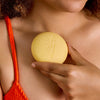 Kate McLeod Sun Stone After Sun Balm & Lotion Bar (3.5 oz) - product shown being held against skin. 
