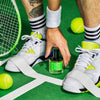 Lifestyle shot of D.S. & Durga Crush Balls Eau de Parfum (50 ml) with model reaching down for bottle with tennis racket and tennis balls in the background