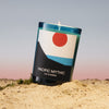 Lifestyle shot of D. S. & Durga Pacific Mythic Candle (7 oz) shown with flame sitting in sand