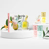 Lifestyle shot of Solinotes Paris Feel Good Discovery Set - Osmanthus, White Tea, Vanilla (3 x 15 ml) showing box and 3 fragrances with flowers and greenery in the background