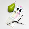 NETTE The Bestsellers Set (2 x 10 ml) box shown partially opened with a vanilla bean and pear on a white background