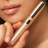 Up close shot of model wearing Chantecaille Brilliant Gloss in Gleam and showing tube