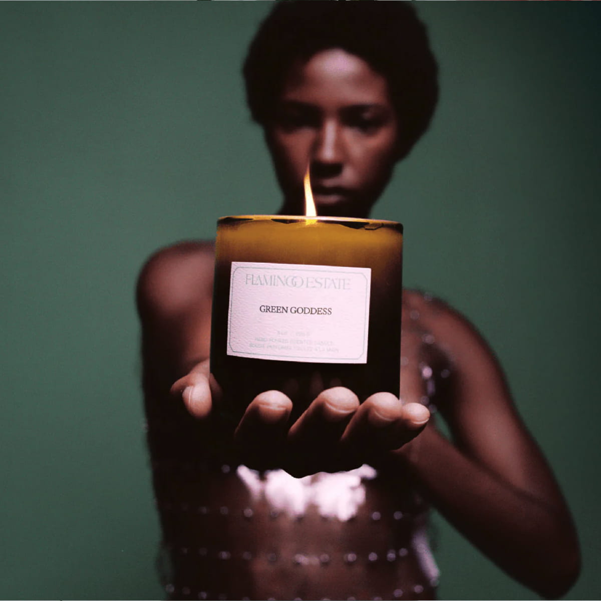 Flamingo Estate Green Goddess Candle (226 g) - product shown being held out by model. 