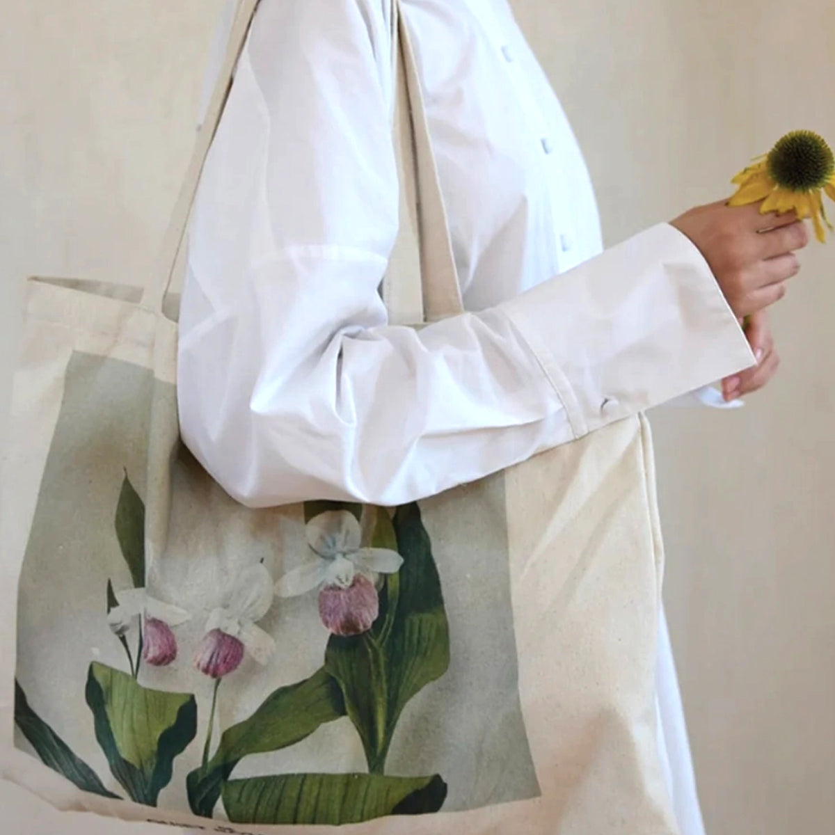 The Quiet Botanist Floral Tote Bag over the shoulder of model