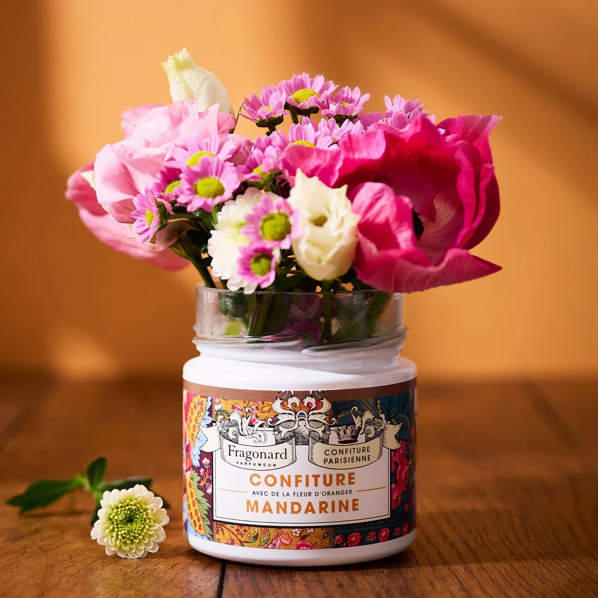 Confiture Mandarine Fragonard X Confiture Parisienne is shown with flowers from the top of the jar
