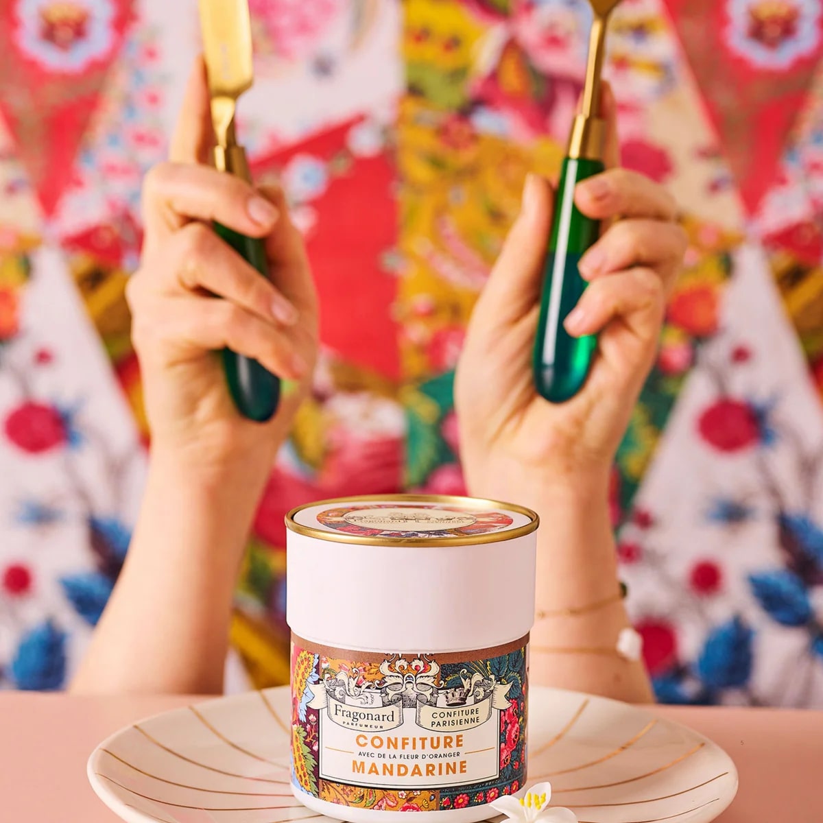 Confiture Mandarine Fragonard X Confiture Parisienne shown with hands holding silverware behind jar