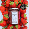 Puckett’s Pickles Strawberry Jam (200 g) Jar shown amid a group of strawberry fruit with a seal that says great taste 2022.