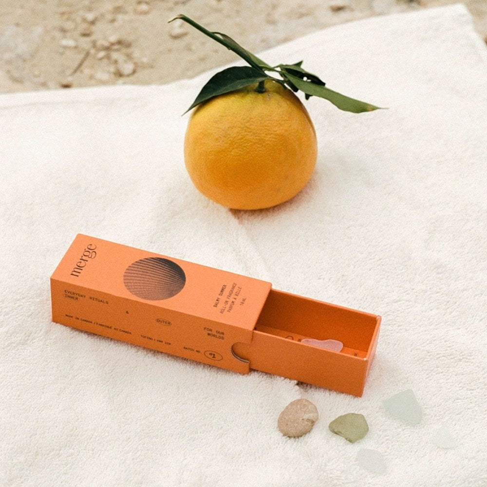 Merge Balmy Summer Roll-On Perfume Oil - open box shown next to fruit and stones