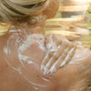 Under Luna Body Cleanser - product shown being used on shoulder with hand and soap foam