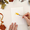 Emily Lex Studio Fall Leaves Paintable Notecards - product shown with paint brush and hands