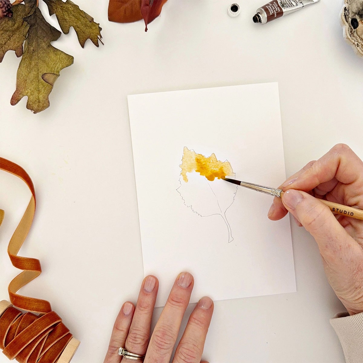 Emily Lex Studio Fall Leaves Paintable Notecards - product shown with paint brush and hands