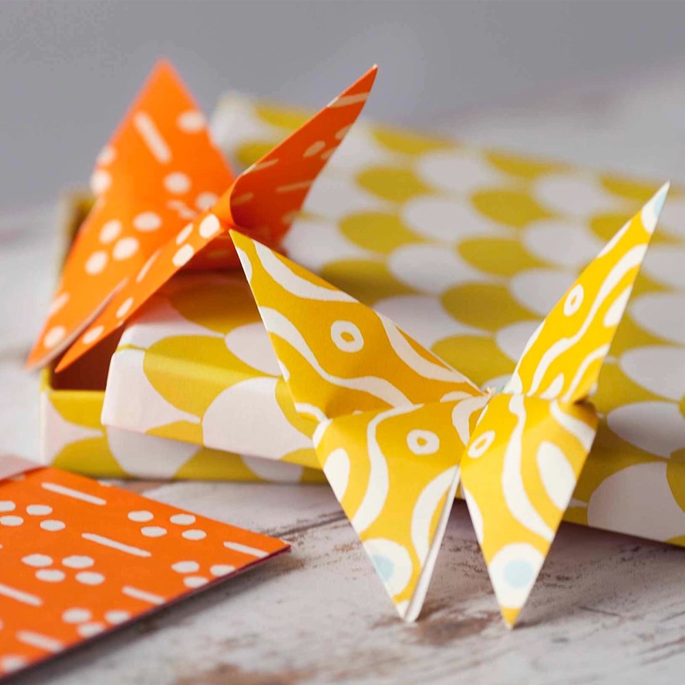 Cambridge Imprint Origami Cloud of Butterflies Kit (36 pc) on a wooden surface with a blurred background